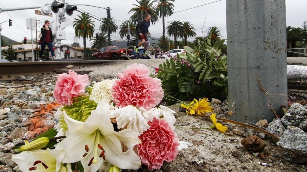 Bouquets of flowers mark the site where Cal Poly student Thomas Stone was fatally hit by a train at Foothill Boulevard near California Boulevard on Tuesday.