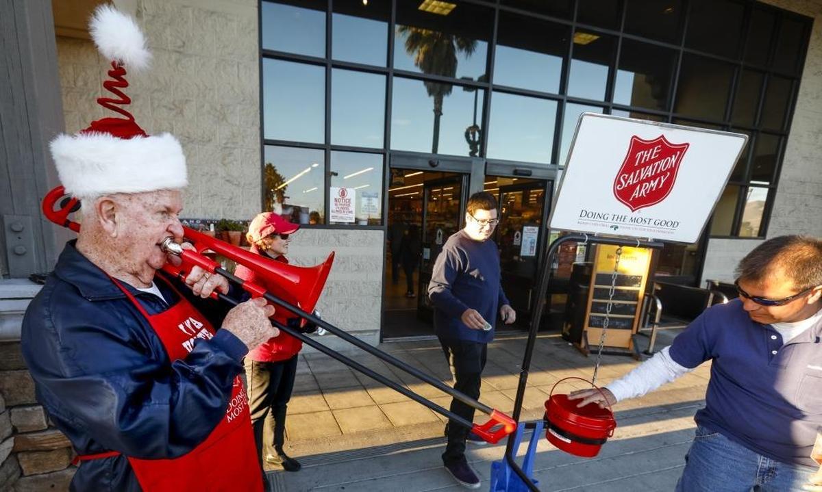 Bruce “Scotty” Scott plays trombone as his wife Janice bell-rings for Salvation Army’s Red Kettle collection at the Vons in Nipomo.