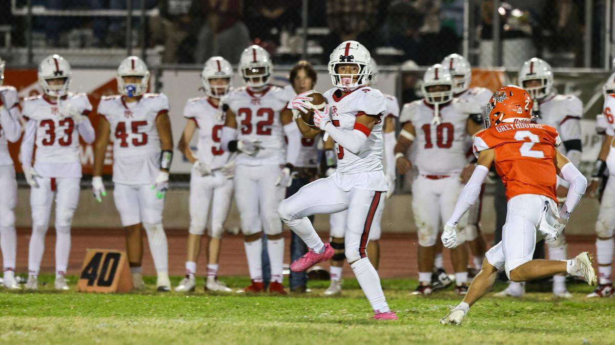 Tre Clark with a Bearcat catch and run pursued by Tyson Tenhaeff. Paso Robles beat Atascadero 30-15 on Sept. 30, 2024.