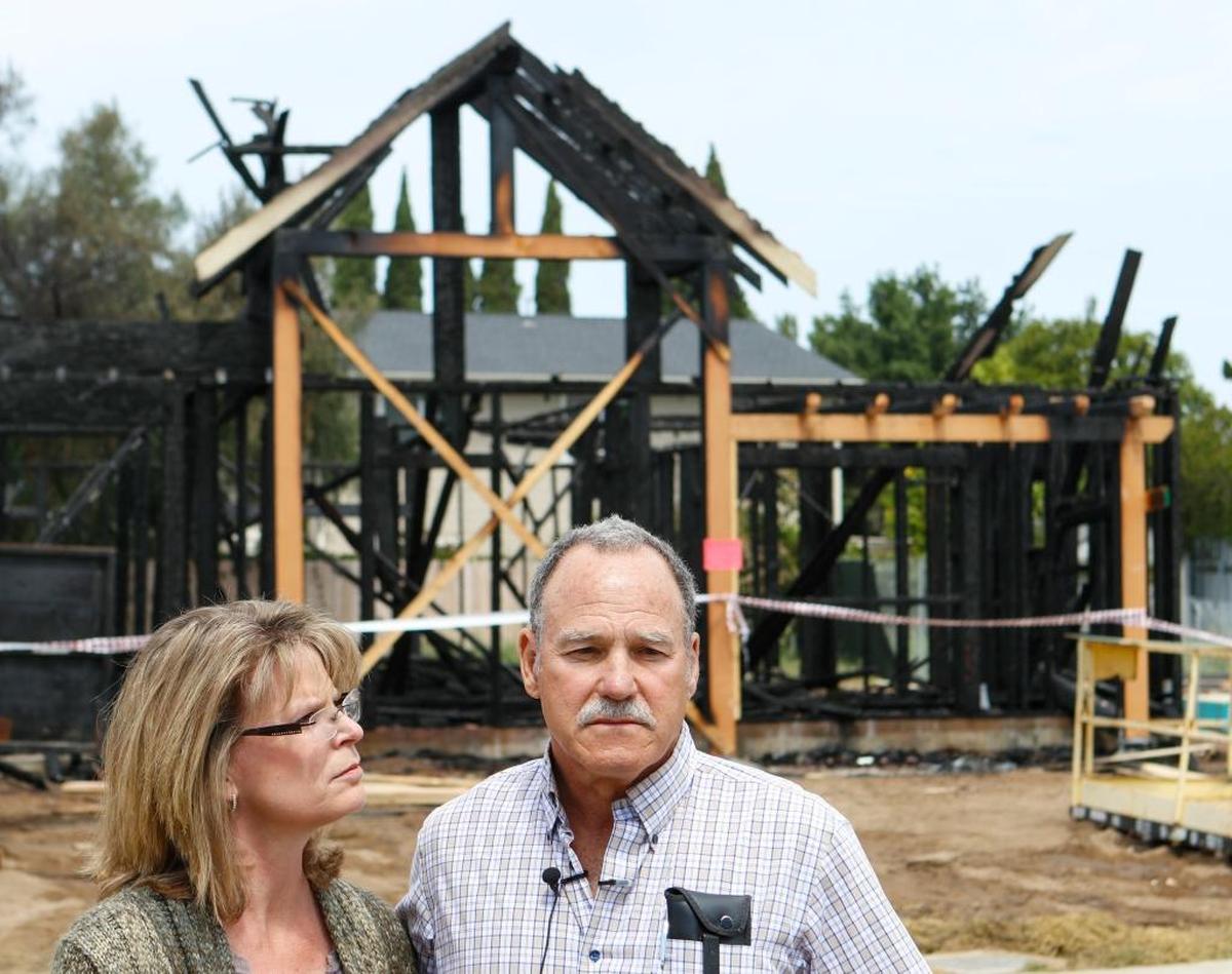 Strawberry farmers Donna and Greg France are shown in front of a Nipomo home burned by an arsonist in April 2016. They had planned to house farmworkers there. The case remains unsolved.