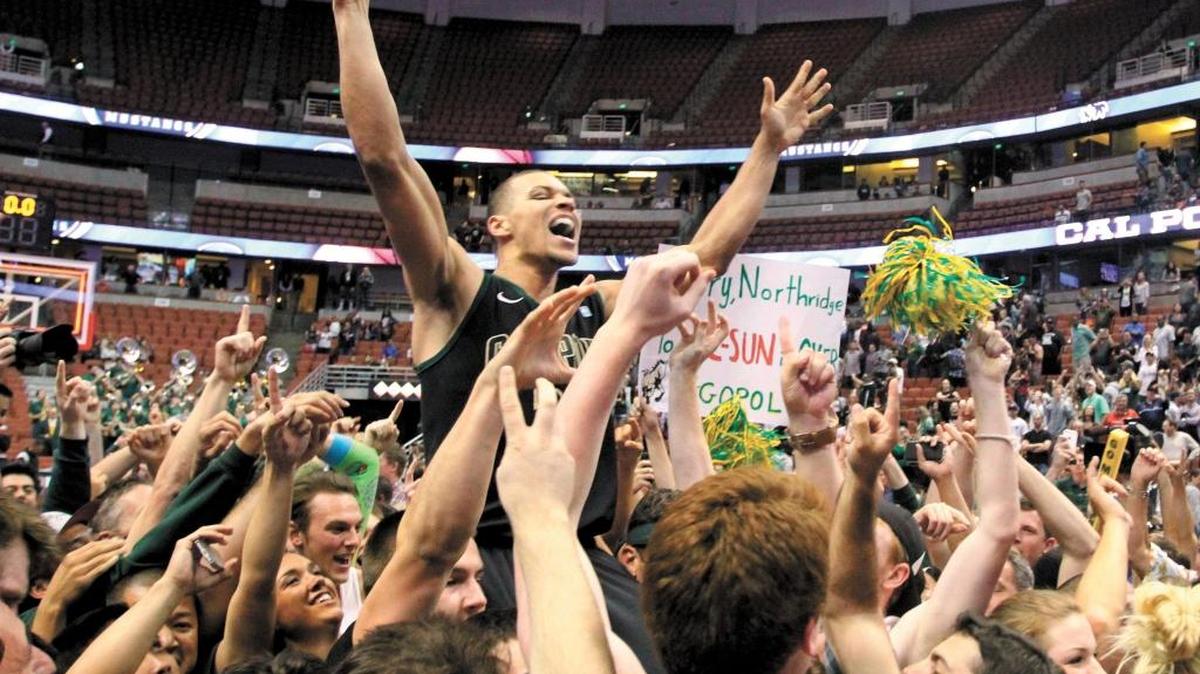 Team members lift Chris Eversley on their shoulders as fans storm the court following the final buzzer in the Big West Converence title victory over Cal State Northridge in March 2014.