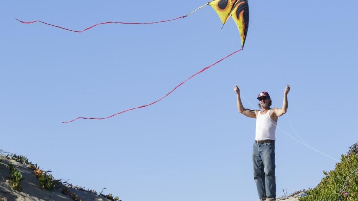 Alan Eddy of Oceano tries to get a two-string trick kite airborne under wind conditions that were unusually light. Warm weather brought beachgoers out to the dunes in Oceano near the Pier Avenue ramp last week.