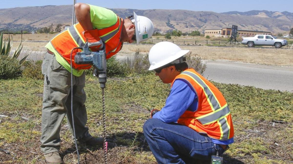 Greg Mortka, left, and Mark Nishibayashi install a passive soil gas probe near the San Luis Obispo County Regional Airport fire station. Areas of the SLO airport have been tested for TCE to determine the source of contamination in nearby wells.