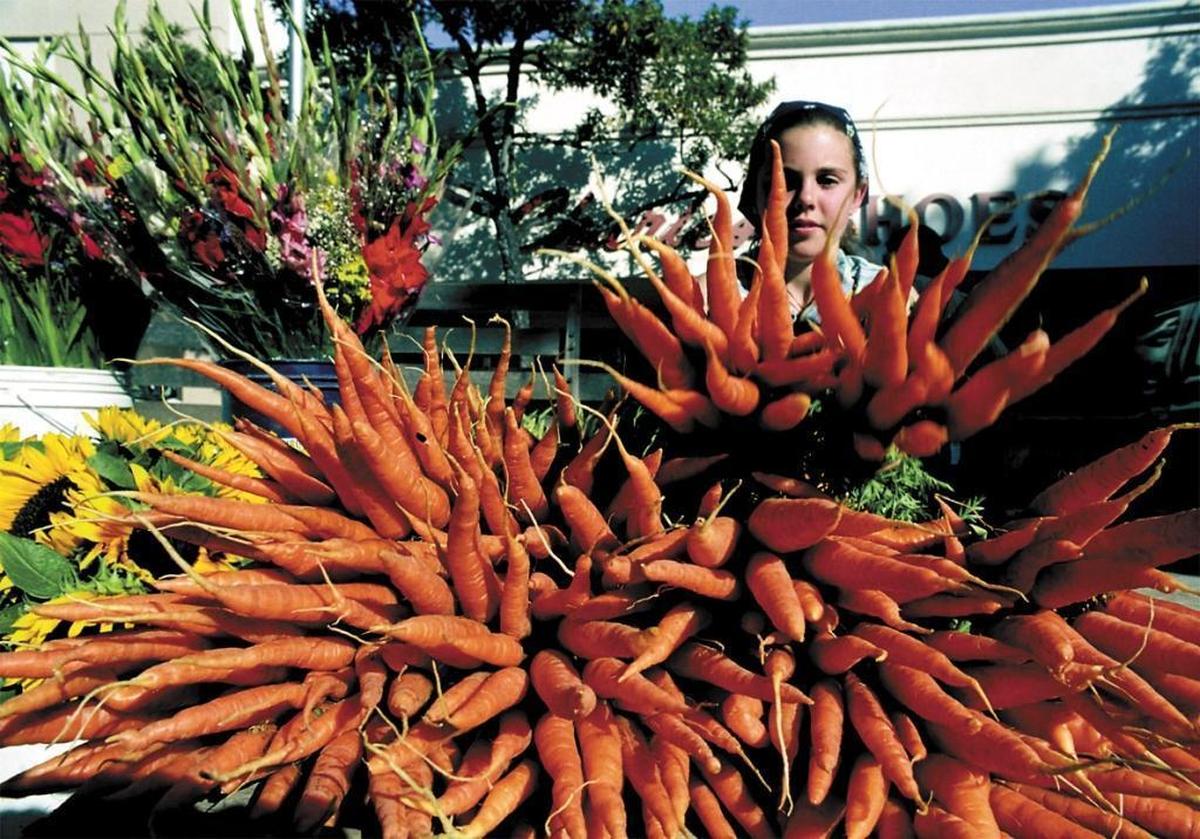 Julianne Rutiz, 11, shows off bundles of fresh carrots at San Luis Obispo’s Downtown Farmers Market in 2017.