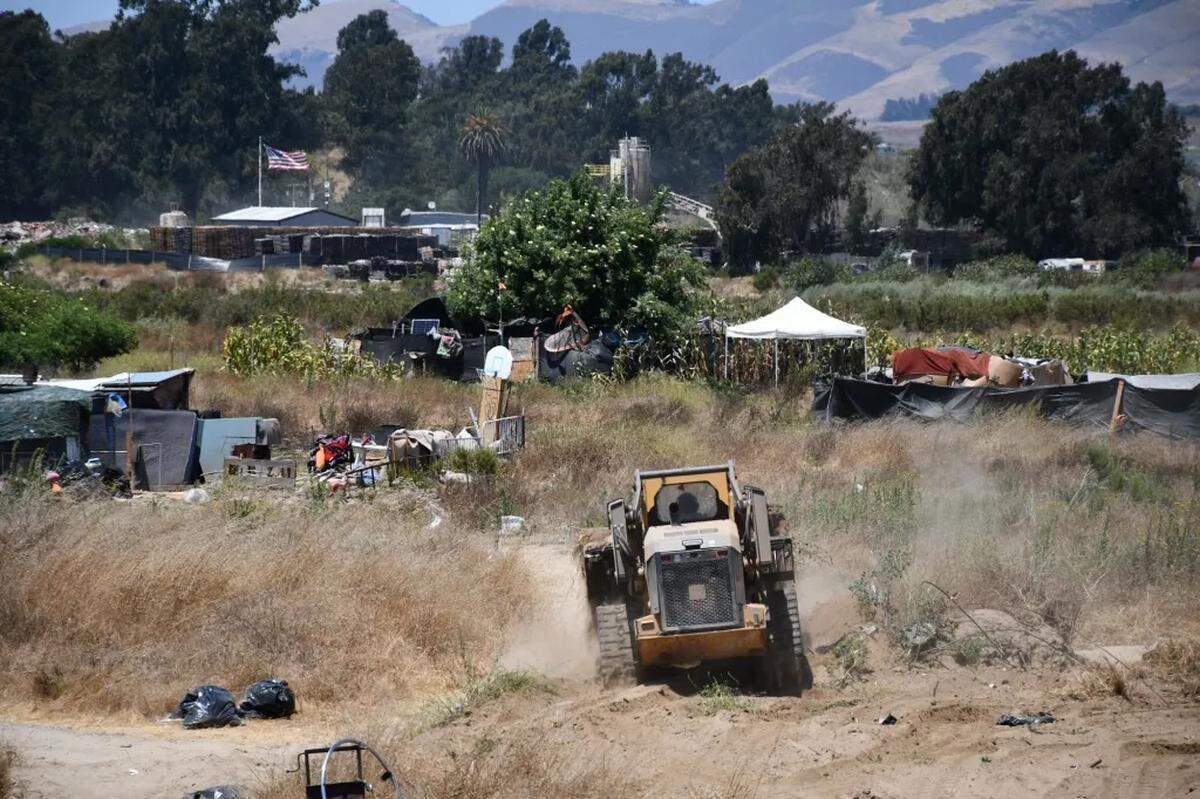 Workers remove homeless encampments in the Santa Maria Riverbed on Thursday, July 26, 2024, as part of a coordinated cleanup effort led by Santa Barbara County, although the area falls under the jurisdiction of San Luis Obispo County.  