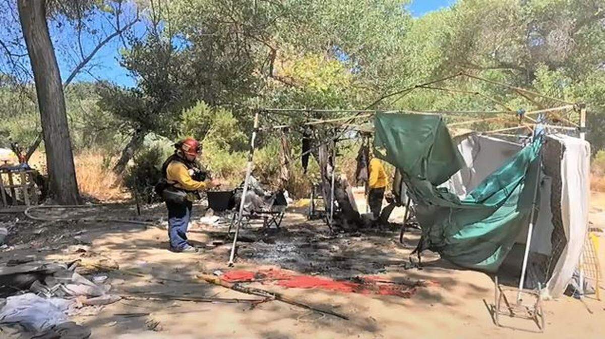A Paso Robles firefighter responds to a fire near a homeless encampment in the Salinas Riverbed. The city began cleaning up encampments in the riverbed during the summer and constructed a temporary camp for homeless residents at the Borkey Flats site.