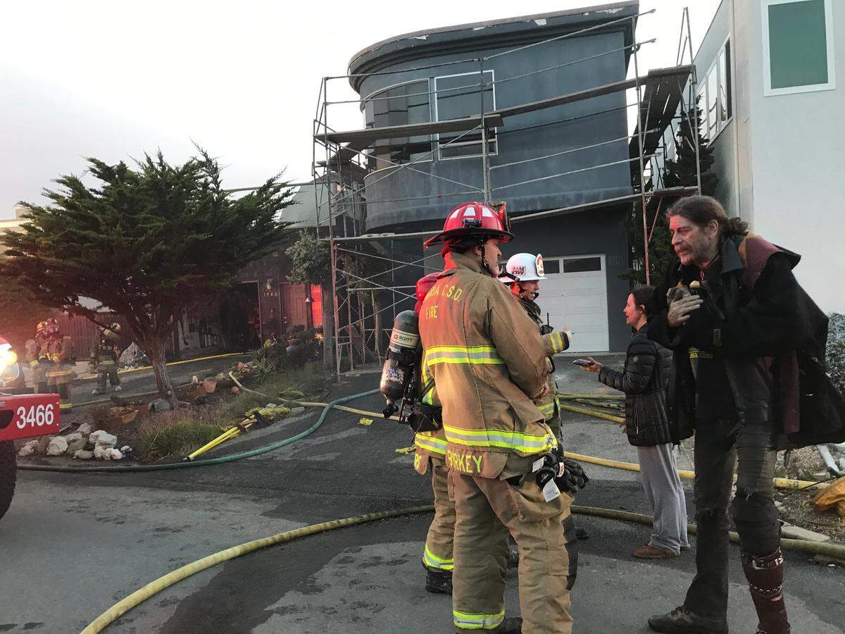 Displaced and dazed homeowners Leland and Marissa Powels, at left, get an update from Mike Burkey, acting fire chief for the Cambria Fire Department. The Powels’ Cambria home was ravaged by an early morning fire on Thursday, Oct. 20, 2022.