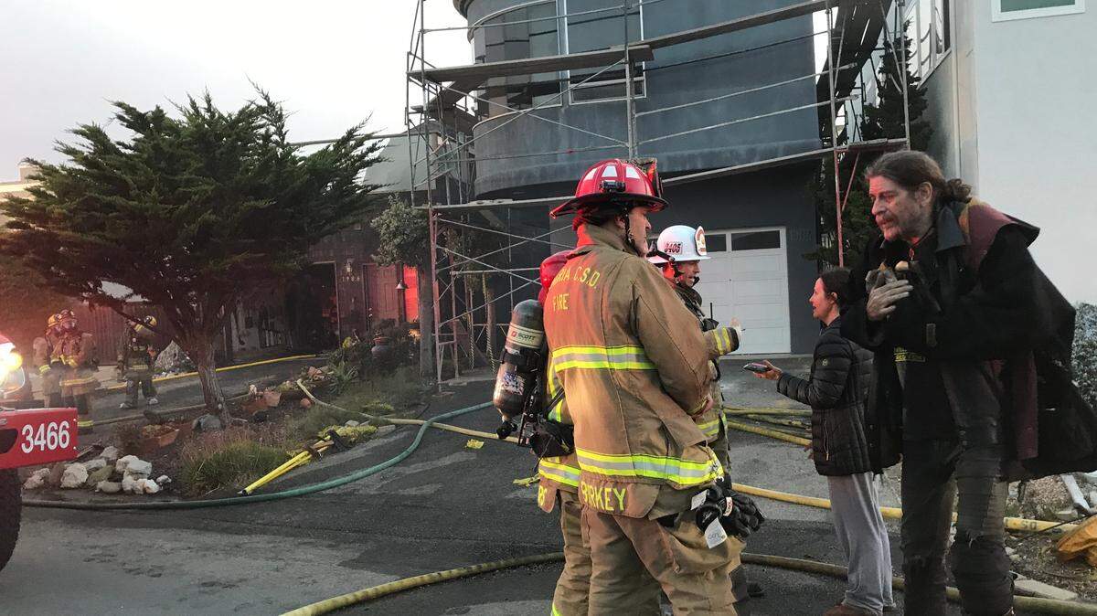 Displaced and dazed homeowners Leland and Marissa Powels, at left, get an update from Mike Burkey, acting fire chief for the Cambria Fire Department. The Powels’ Cambria home was ravaged by an early morning fire on Thursday, Oct. 20, 2022.