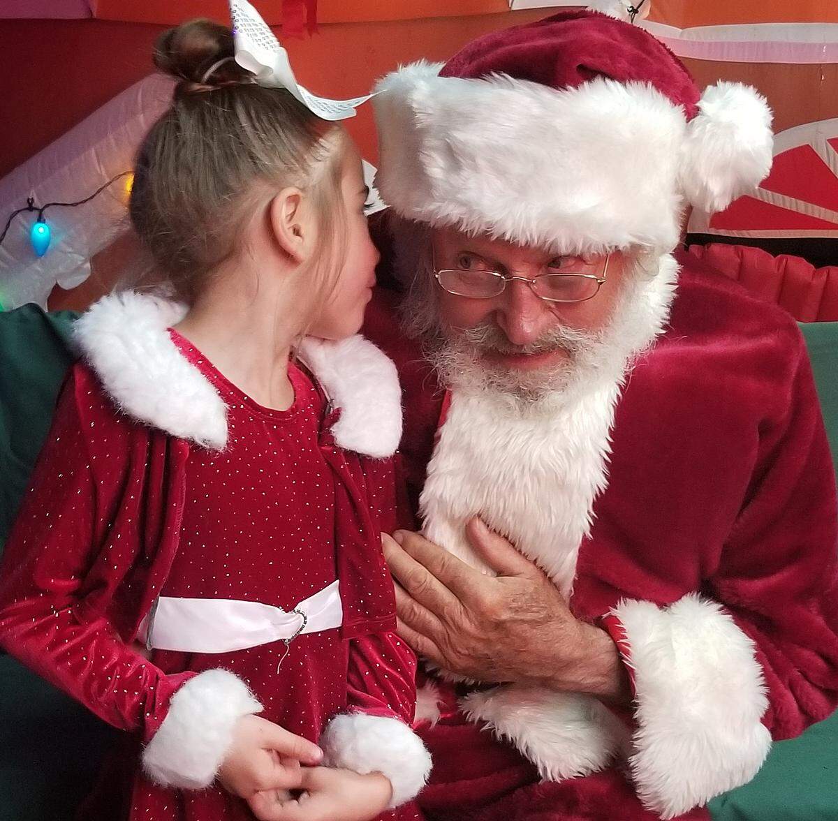Tom Tierney as Santa listens intently to the hopes and wishes of an unidentified young fan in Cambria in 2019.