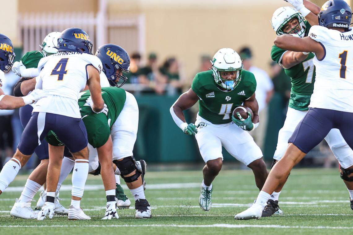 Cal Poly running back Mark Biggins (4) shuffles through a hole in the line during the Mustangs’ 24-17 over Northern Colorado on Saturday, Oct. 21, 2023, at Mustang Memorial Field.