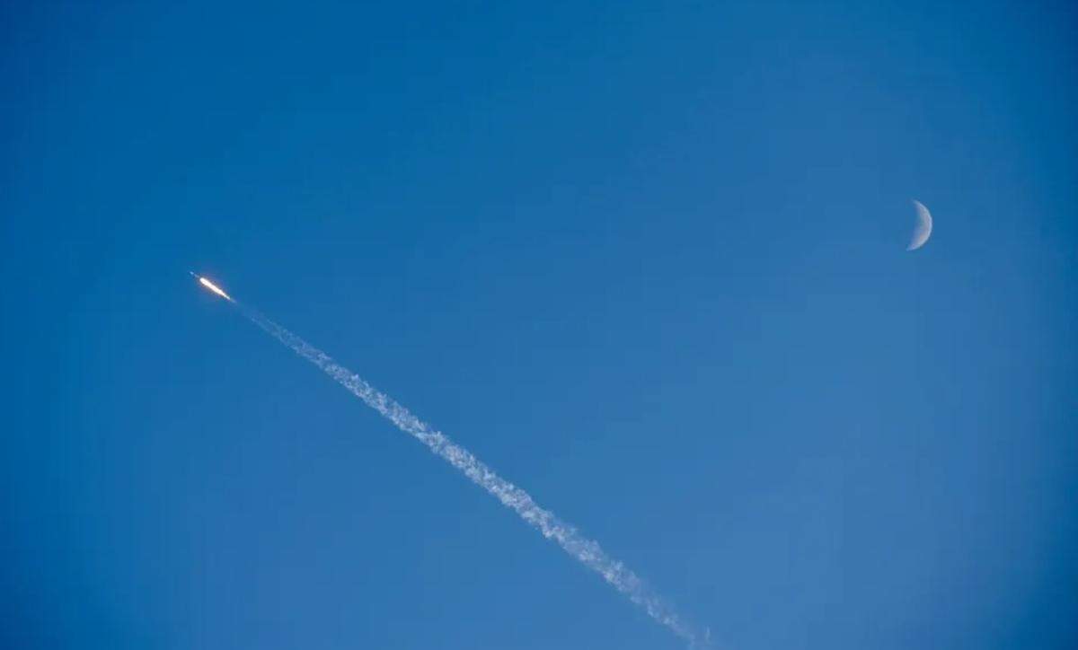 With the moon visible, the SpaceX Falcon 9 rocket rises from the Central Coast after lifting off Thursday night, July 11, 2024, from Vandenberg Space Force Base.