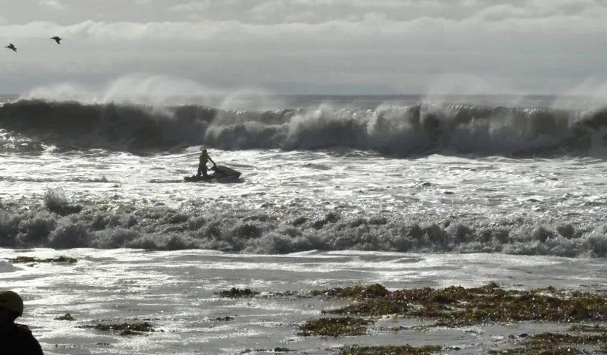 County Fire ocean rescue crews help surfers to shore in Isla Vista on Thursday morning, Dec. 28, 2023, after high tides and big waves hammer the coastline.