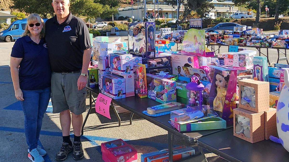 Dave Ehlers, right, is the Cambria Chamber of Commerce’s 2023 citizen of the year. He and wife Jennifer “Jenn” Ehlers stand in front of just part of this year’s donations for Toys for Tots, one of several nonprofits, groups and volunteer endeavors that earned him the honor. 