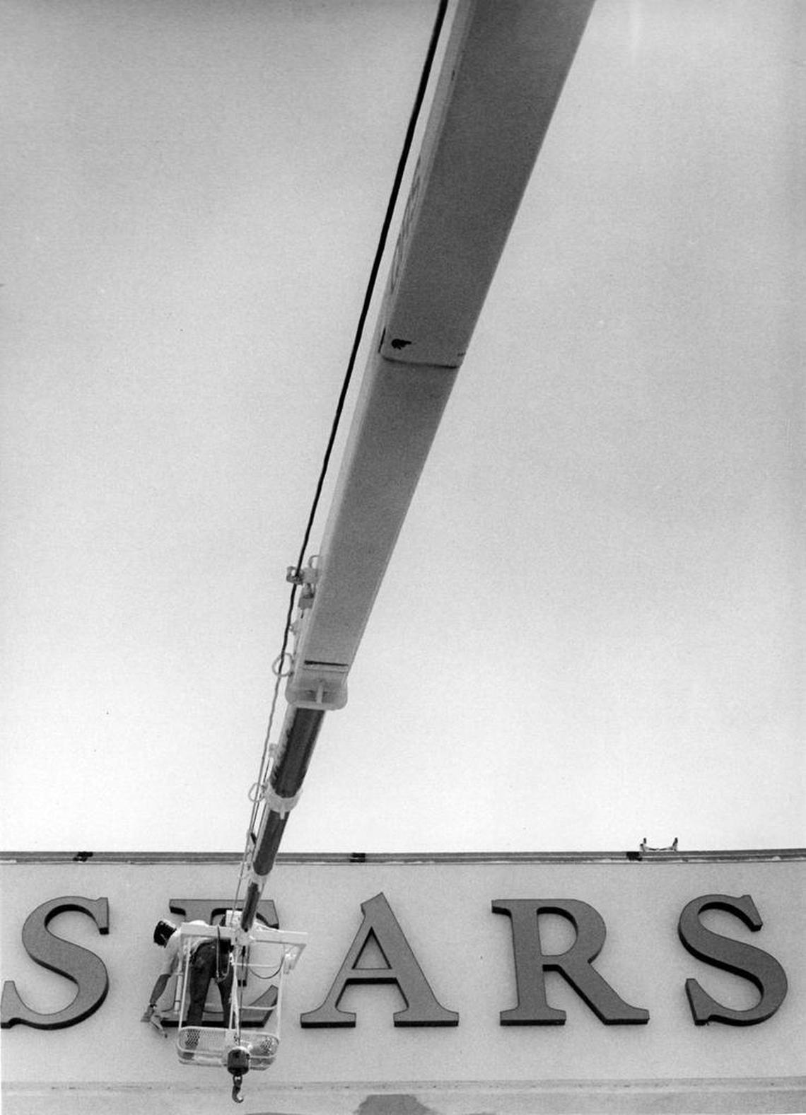 A worker installs the sign on the Sears store at the Madonna Plaza, prior to its opening on August 11, 1976.