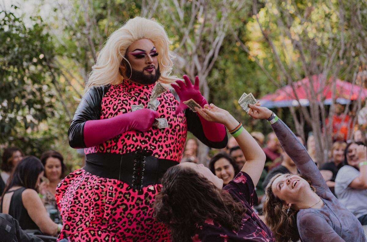 Audience members hand tips to Juicy CW while she performs at Art and Soul SLO’s Drag Night.