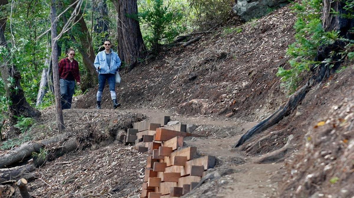 In this photo taken March 30, 2017, two women walk north on the new Pfeiffer Canyon foot trail that is open to residents traveling around the former Pfeiffer Canyon bridge in Big Sur. The trail opened to the public on July 1, 2017.