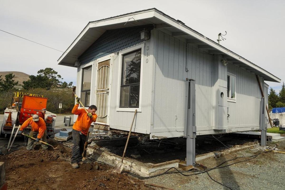 Scott James and his wife Gayle donated their Cayucos beach home to a woman who moved it across town on Monday with the help of Brandt House and Building Movers. Here, workers remove a portion of the foundation so a trailer can be placed under the home.