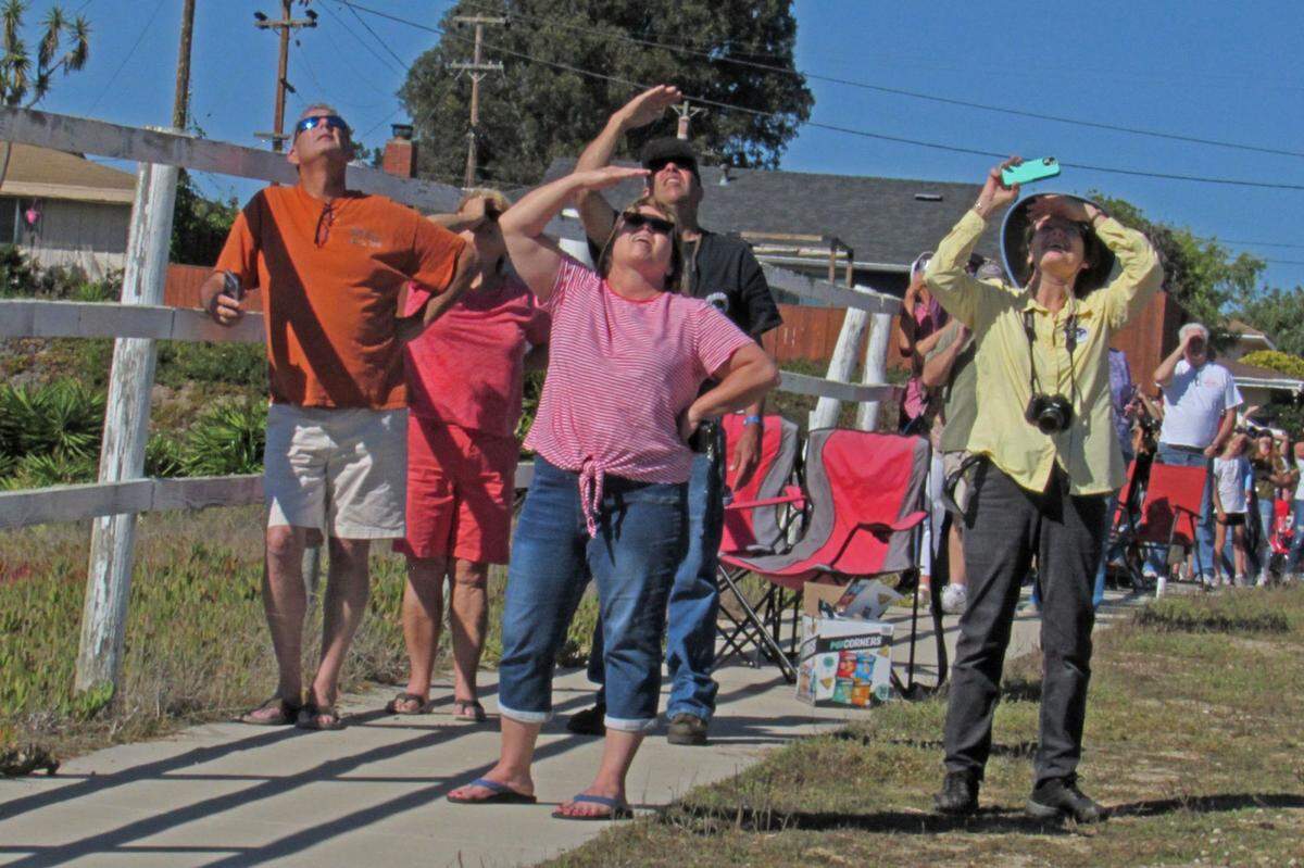 Spectators look skyward as a Delta IV Heavy rocket heads toward space from Vandenberg Space Force Base on Saturday.