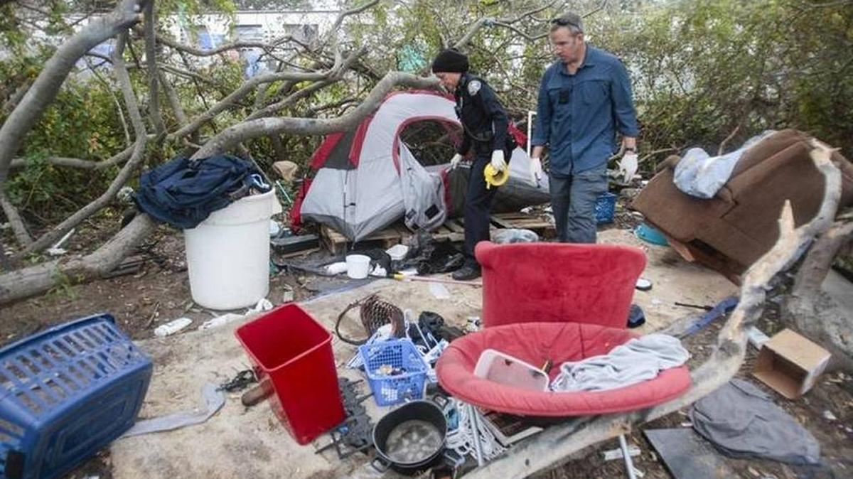 Morro Bay City Manager David Buckingham, right, clears a homeless encampment with Police Chief Amy Christey ahead of winter storms in December 2015.