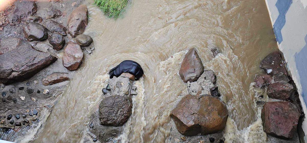 A sleeping bag is caught on a rock in San Luis Creek in downtown San Luis Obispo on Feb. 19, 2024, as a powerful storm dropped an onslaught of rain on San Luis Obispo County overnight.