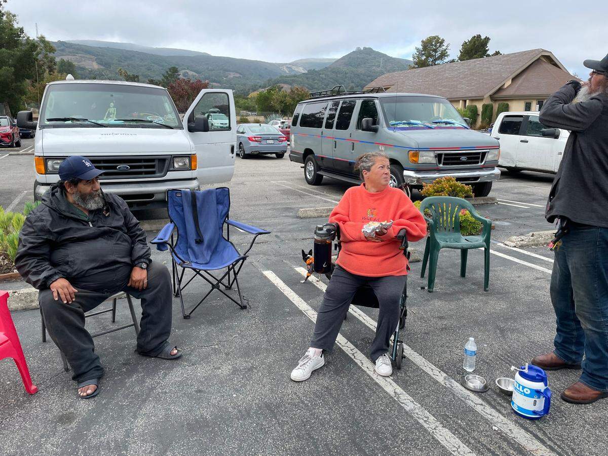 Susan McMiller (middle) chats with her boyfriend, “Grandpa” Gary Perez (right) at the Hope’s Village mobile shower site in SLO at United Church of Christ. The program, which is ending, has been offered Saturdays in SLO.