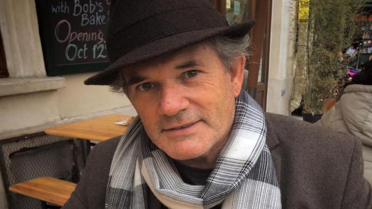 Phil Jenkins enjoys a cup of coffee at a cafe in Paris.