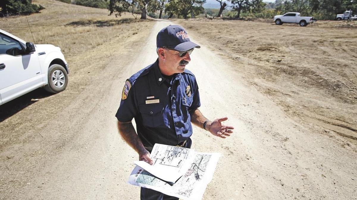 Cal Fire/San Luis Obispo Chief Robert Lewin gives a briefing in August while standing on the road about a quarter of a mile from Santa Margarita, near where fire crews stopped the Cuesta Fire’s advance.