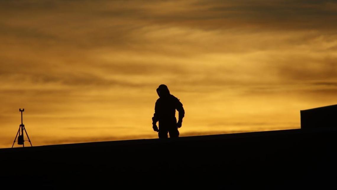 As the sun sets, an officer looks down on the crowd outside Spanos Theatre from a nearby rooftop Tuesday, Jan. 31, 2017, in advance of Milo Yiannopoulos’ talk at Cal Poly.