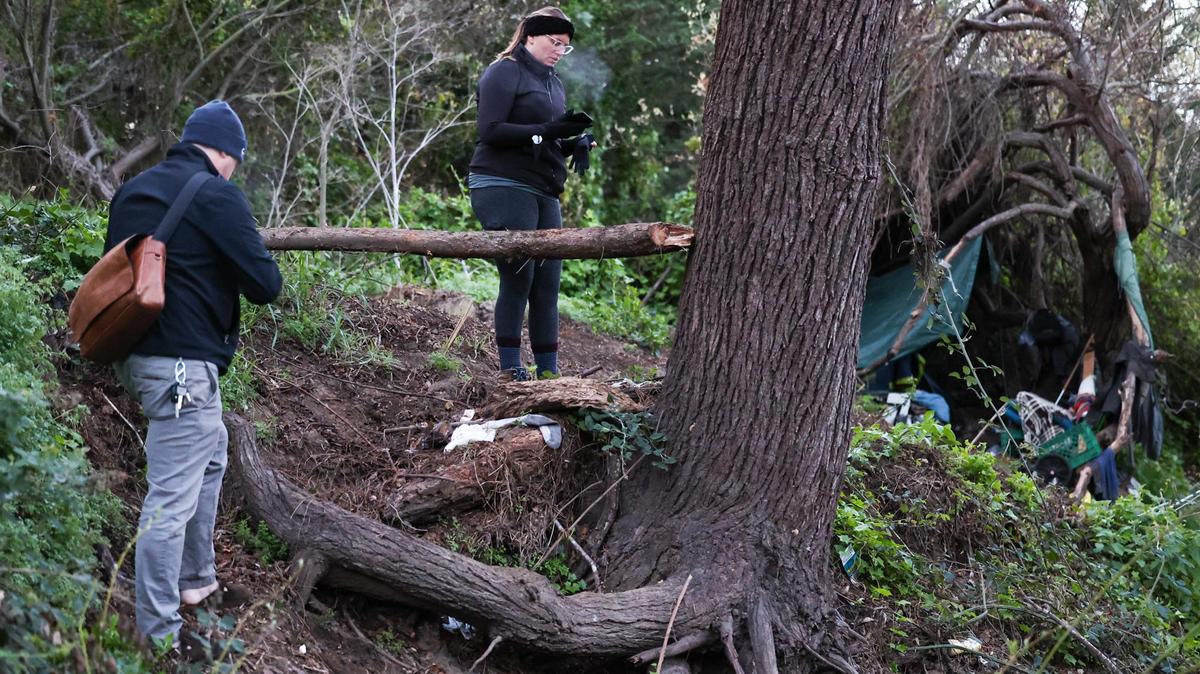 Jack Lahey and Kelsey Nocket document an active campsite in San Luis Obispo Creek near the Bob Jones Trail. Volunteers and staff were out before dawn to count the unhoused in San Luis Obispo County on Feb. 23, 2022.