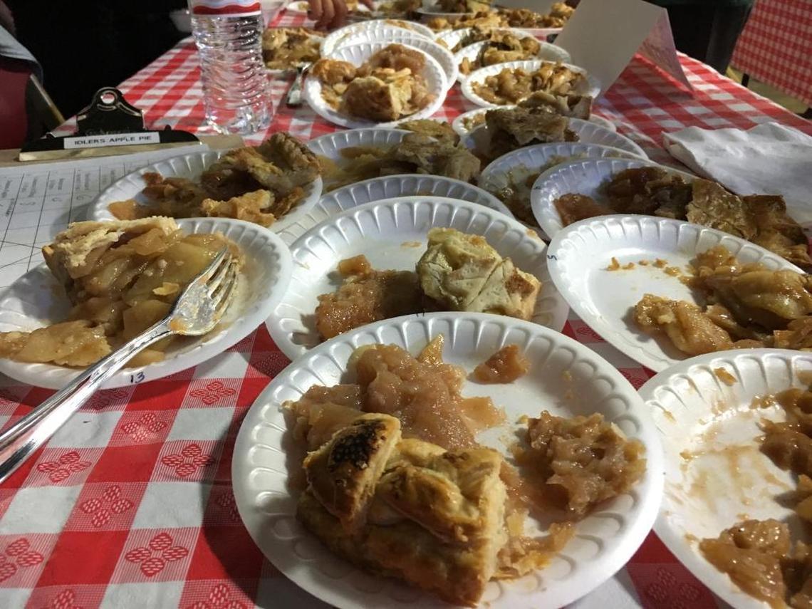 Plastic plates hold the remnants of 13 pieces of apple pie sampled by judge Sarah Linn at the Idler’s Home Mom and Apple Pie competition, held Saturday at the Alex Madonna Expo Center in San Luis Obispo.