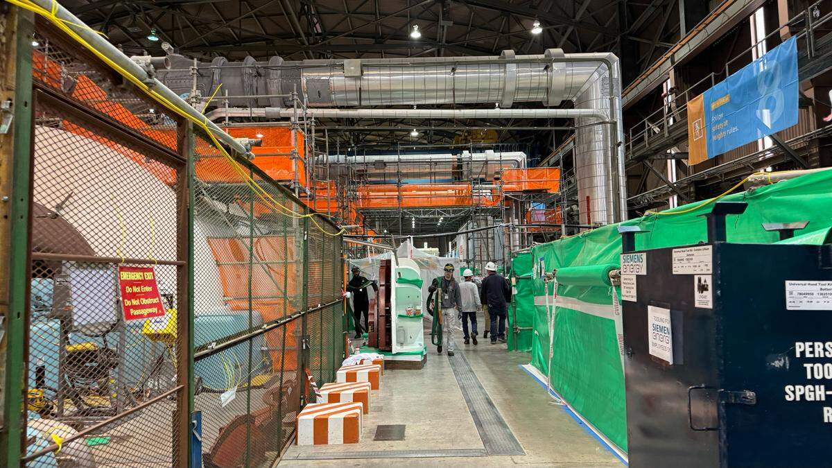 Workers walk through the Diablo Canyon nuclear power plant turbine building during Unit 2’s refueling outage in April 2024.