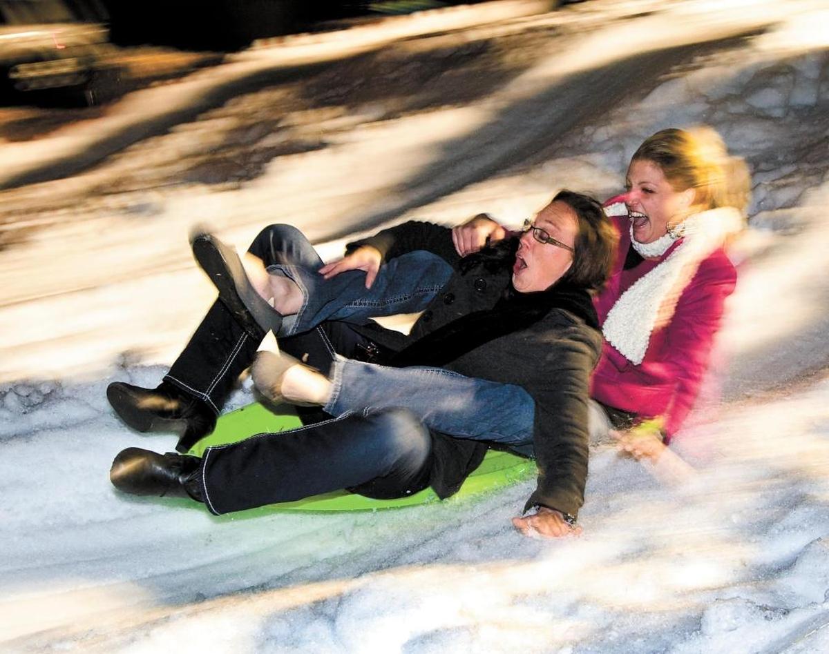 Stephanie Knoop, left, and Crystal Leon zip down a mountain of snow on a sled during the Atascadero Winter Wonderland event in 2013.