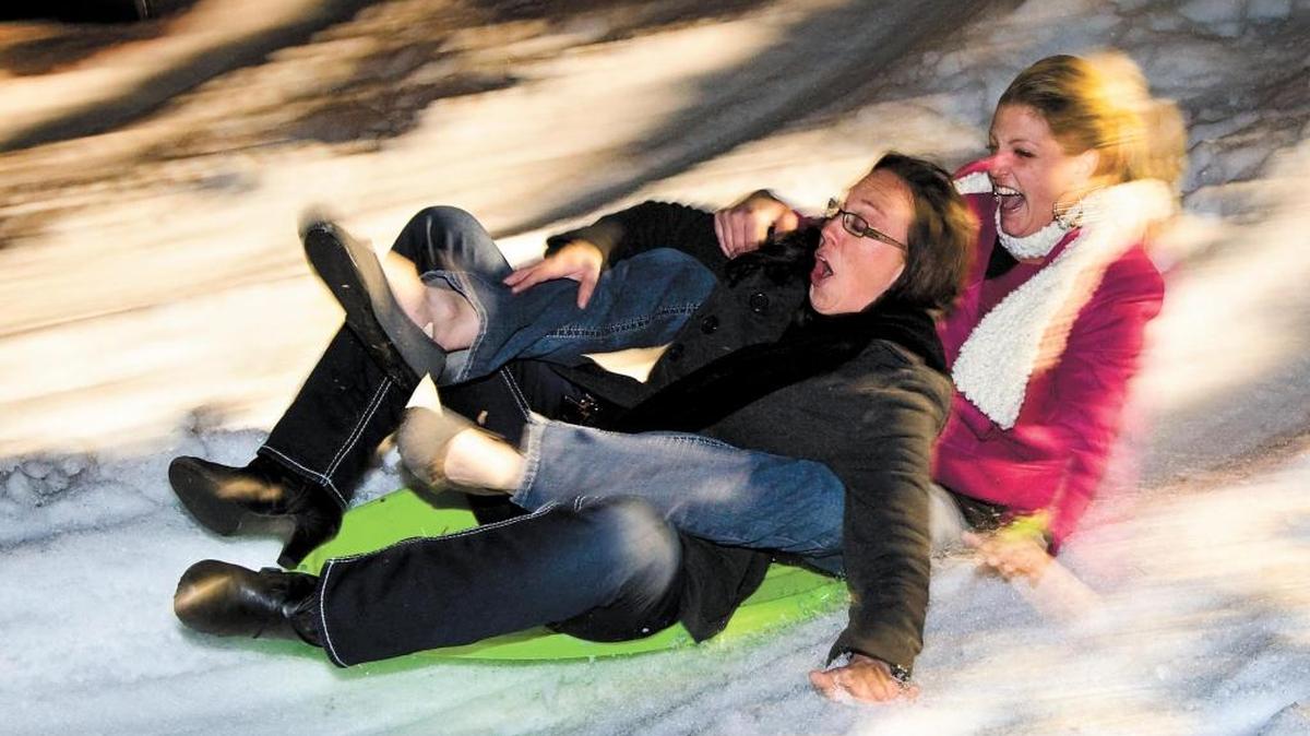 Stephanie Knoop, left, and Crystal Leon zip down a mountain of snow on a sled during the Atascadero Winter Wonderland event in 2013.