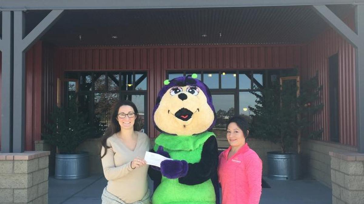 Performance Athletics Gymnastics recently presented $468 to Family Care Network. The money was raised at its Parents’ Night Out fundraiser. Stephanie Anania, left, and Leila Dufurrena, right, of the Family Care Network accept the donation from Performance Athletics Gymnastics mascot Tumble Bug.