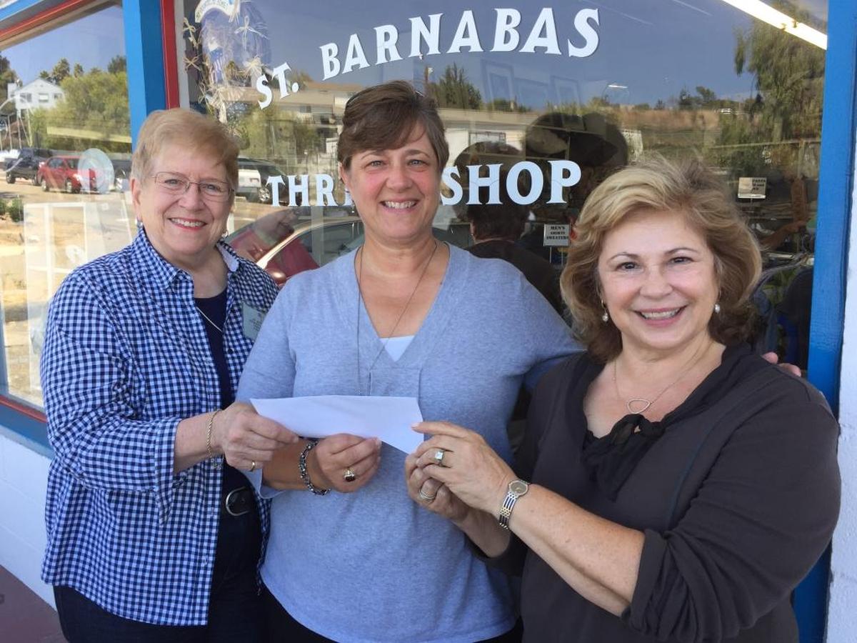 Saint Barnabas Thrift Shop volunteers Judy Burdick, left, and Susan Murray, right, present a check for $1,000 to Jenny Luciano, executive director of the Child Development Resource Center.