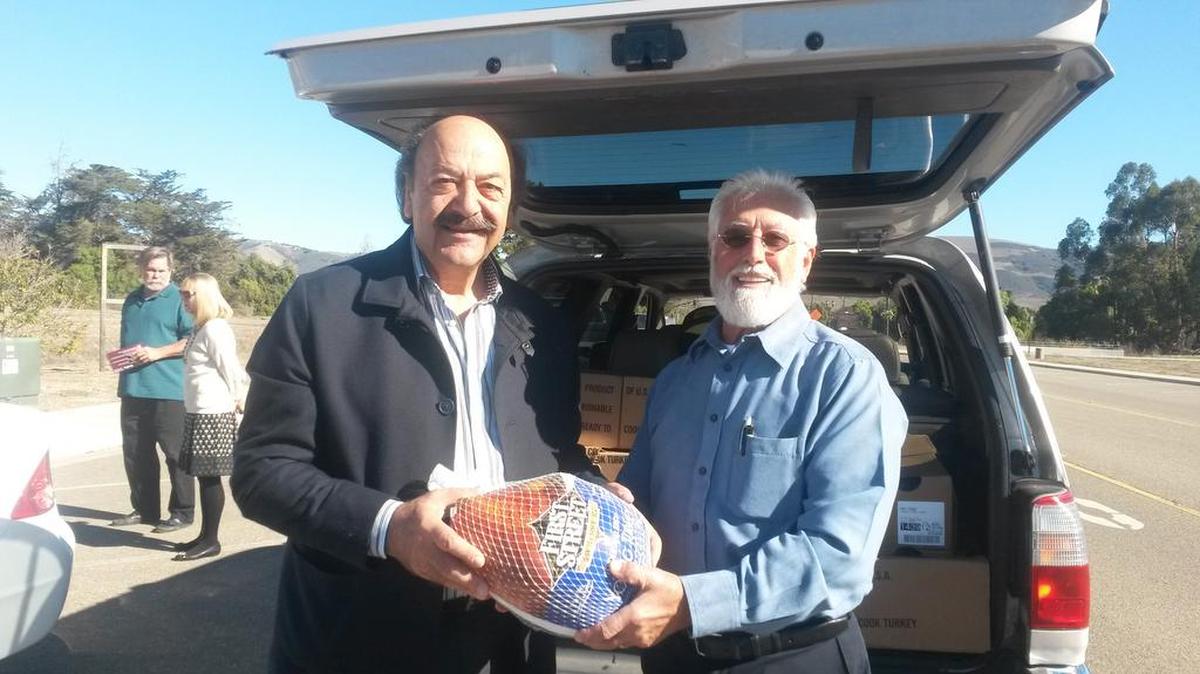 Assemblyman Katcho Achadjian, left, presents one of 25 Thanksgiving turkeys donated by Golden State Water Company to the Senior Nutrition Program. Elias Nimeh, executive director of the program, received the turkeys.