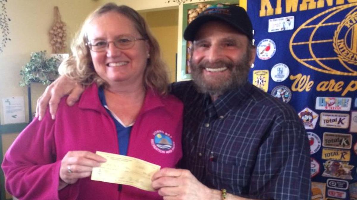 Steve Auslender, chair of the Youth Services Committee for the Bay Osos Kiwanis Club, presents a $700 donation from the club to Morro Bay Recreation Services in support of the department’s sports programs. The check was accepted by Karen Sweeny, sports supervisor for the department.