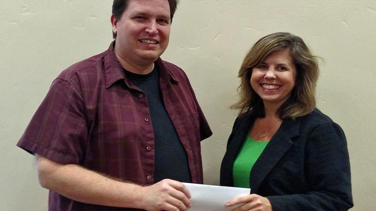 San Luis Obispo Ministerial Association President Jay Perry, left, presents a donation for the Women’s Shelter Program of SLO County to Kirsten Rambo, director of the shelter.