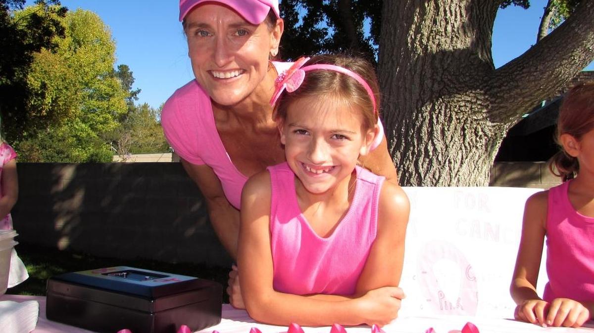 Genevieve Leroux, 10, is pictured with her mother, Kimberlee Leroux, at a funraiser she organized to benefit the Breast Cancer Research Foundation. This was her fourth straight year selling homemade pink ribbons, pink lemonade and pink cookies for breast cancer research.