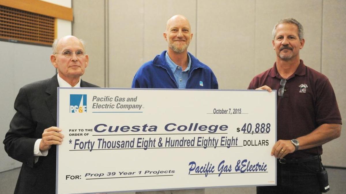 Cuesta College President Gil Stork, left, and Terry Reece, director of facilities services, planning and capital projects for Cuesta, right, accept an incentive check from Tom Lorish, PG&E customer relationship manager.
