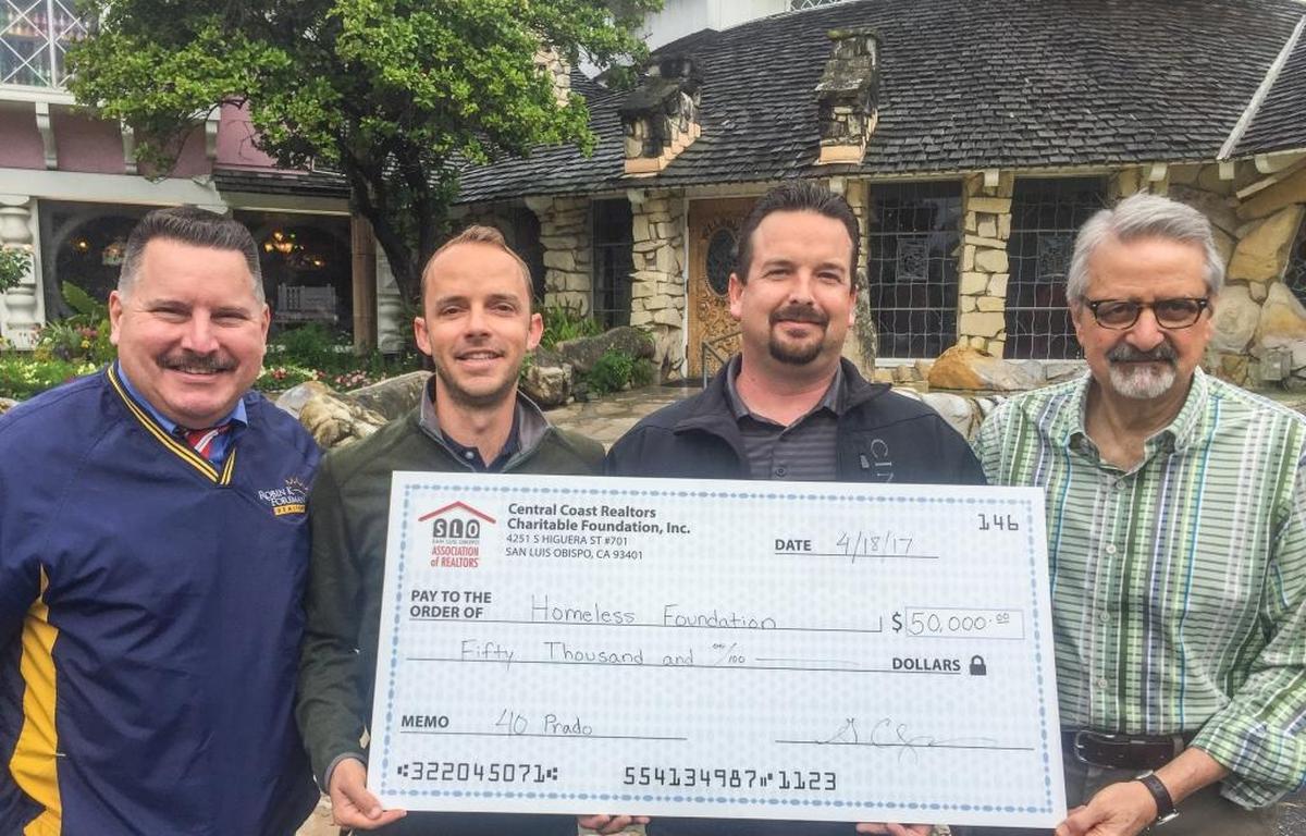 Representatives from the Central Coast Realtors Charitable Foundation, from left, Robin Foreman, Graham Updegrove and Tyler Bennett present a $50,000 donation for 40 Prado to John Spatafore, president of the Homeless Foundation of SLO County.