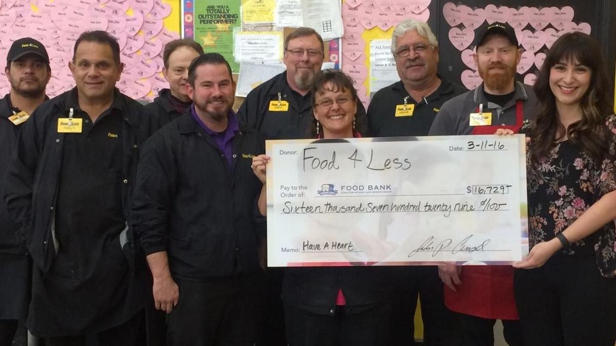 Food 4 Less employees present a donation to Aracely Aceves Lozano, center, director of community relations at the Food Bank Coalition of San Luis Obispo.