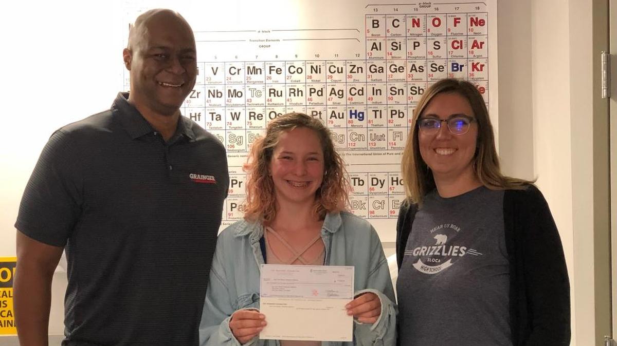 Ben Wise from Grainger, left, presents Ava Faber, a San Luis Obispo Classical Academy High School junior, and Paige Bartel, a San Luis Obispo Classical Academy High School biology teacher, with a check in the amount of $2,500 to purchase microscopes for the classrooms.