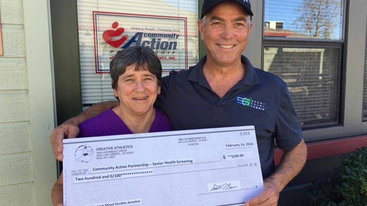 Heather Murphy, left, receives a donation on behalf of CAPSLO from Scott Cleere, tournament director of Feel the Love tennis tournament.