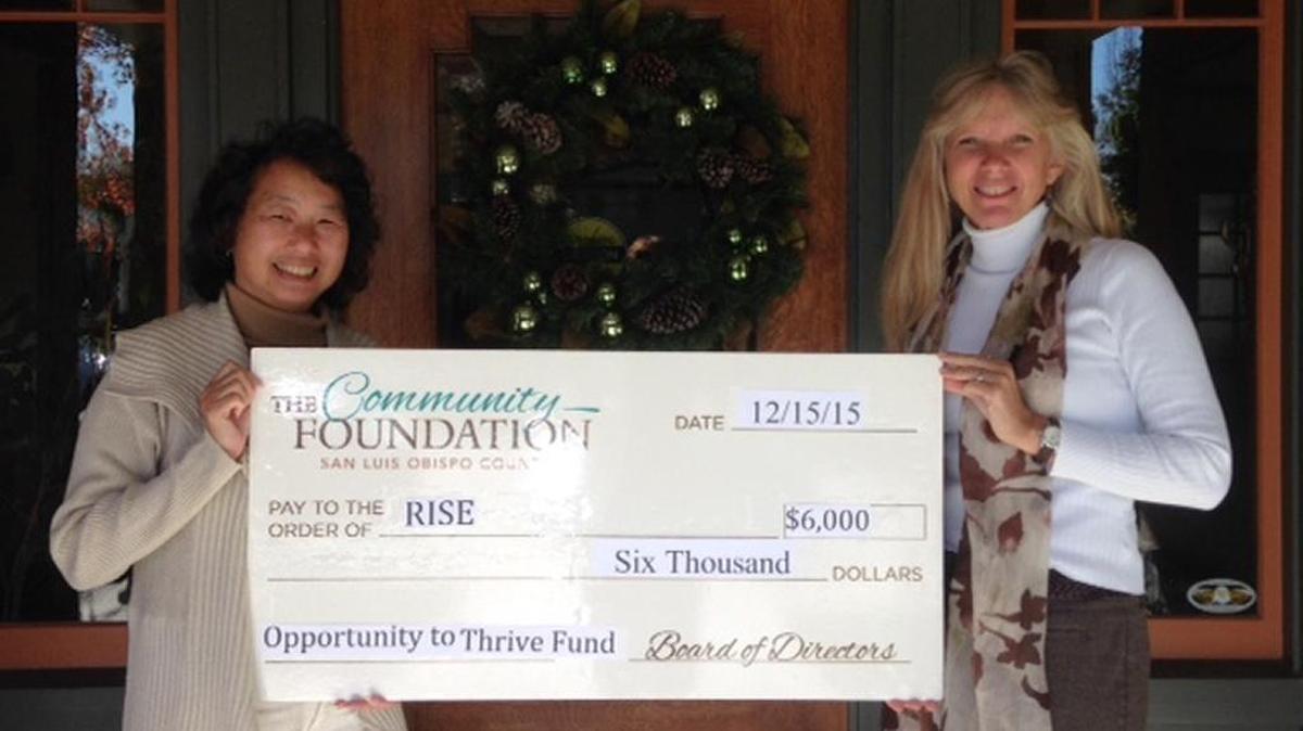 Janice Fong Wolf, left, director of grants and programs at The Community Foundation San Luis Obispo County, presents a check for RISE to Jennifer Adams, executive director of the organization.