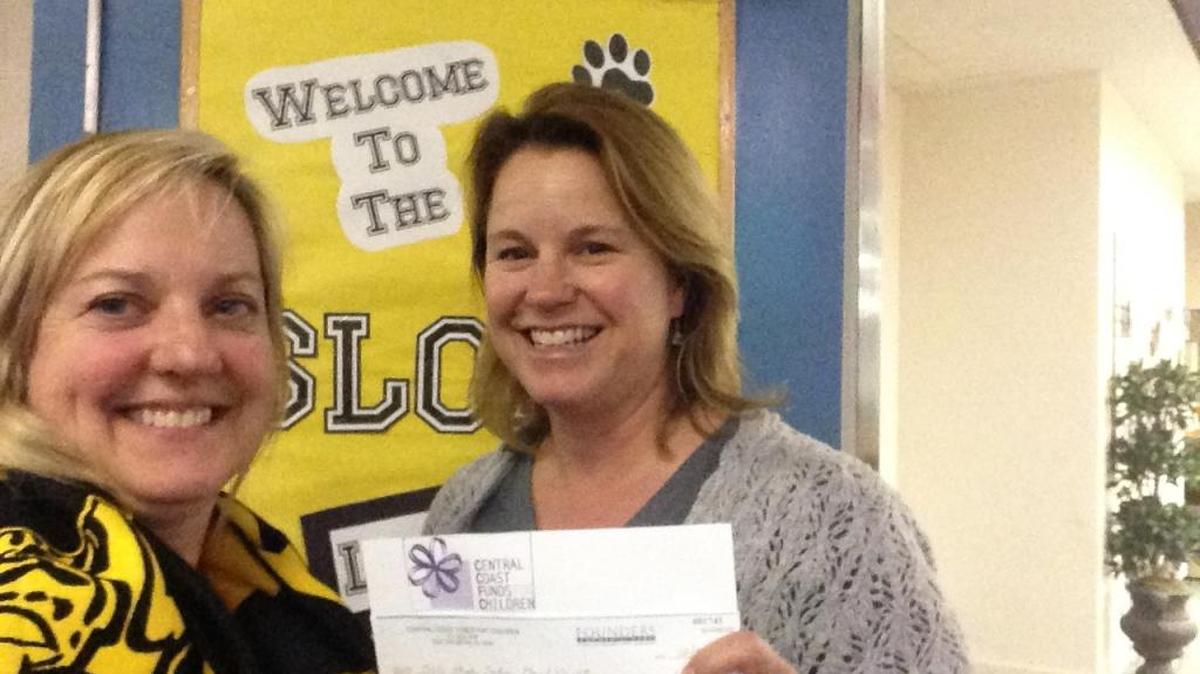 San Luis Obispo High parent volunteers, Bonnie Burt (left) and Jill Chan (right), display the $1,000 donation check received from Central Coast Funds for Children for the upcoming Grad Night event