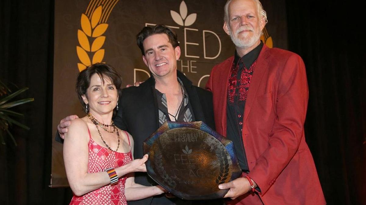 Christy Pipkin, left, and her husband Turk Pipkin, right, present the 2016 Founder’s Award to Austin Hope, center, from The Nobelity Project at an awards dinner held in Austin, Texas.