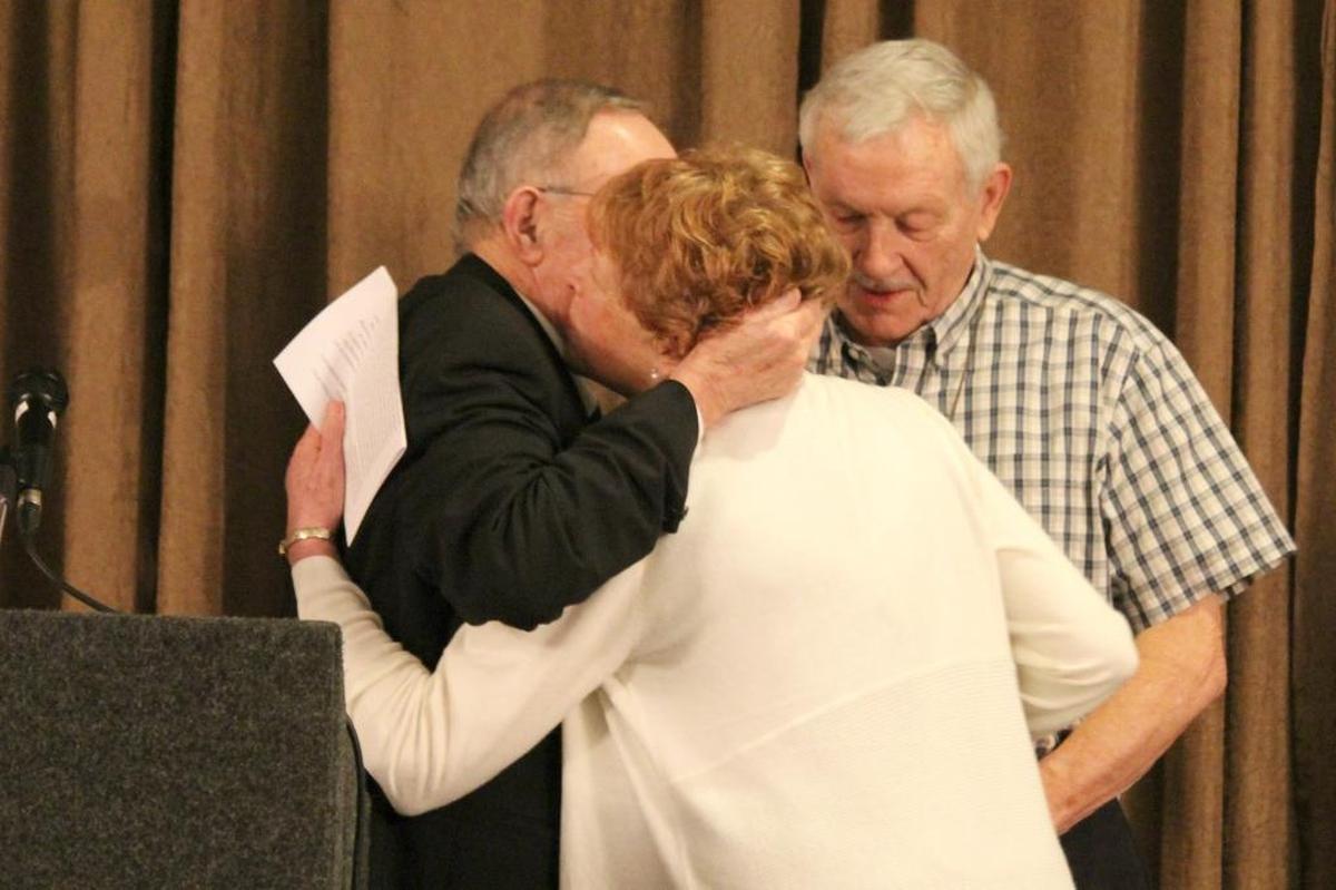 Cambria Chamber of Commerce President Mel McColloch, left, hugs Sue Robinson as Roger Robinson looks on at the Person of the Year awards presentation Tuesday.