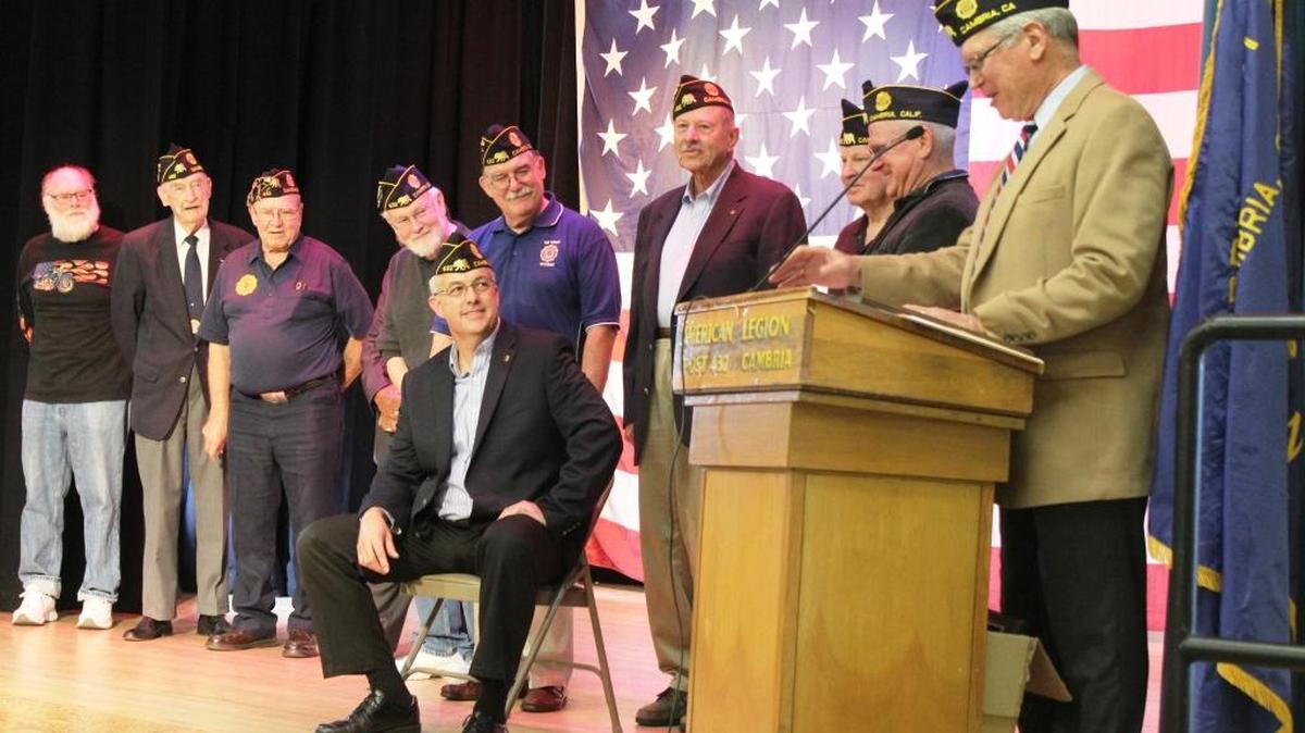 Members of the American Legion Post 432 leadership present Dave Ehlers, seated, with the Don Bowman Patriot of the Year Award on Friday at the Veterans Memorial Building in Cambria. At the microphone, making the presentation, is Greg Sanders.