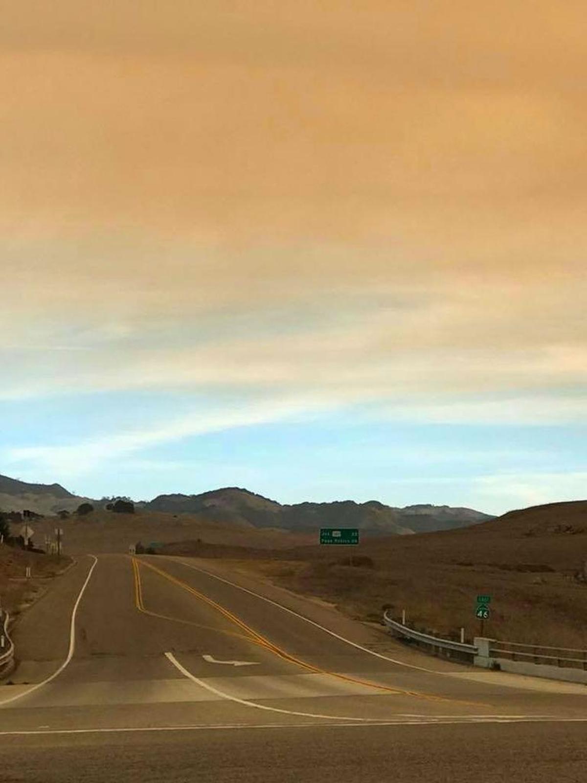 Orange smoke competes with blue sky, looking east down Highway 46 at the Highway 1 junction Sunday morning.